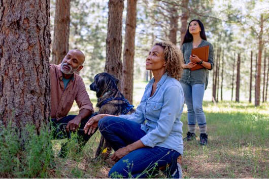 Husband, Wife and Dog explore Memorial Tree options in a Memorial Forest with a Guide.