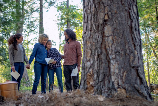 Family gathered around a Memorial Tree holding a Forest Memorial ceremony.