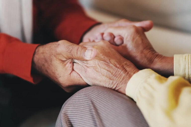 Senior couple holding hands in comfort