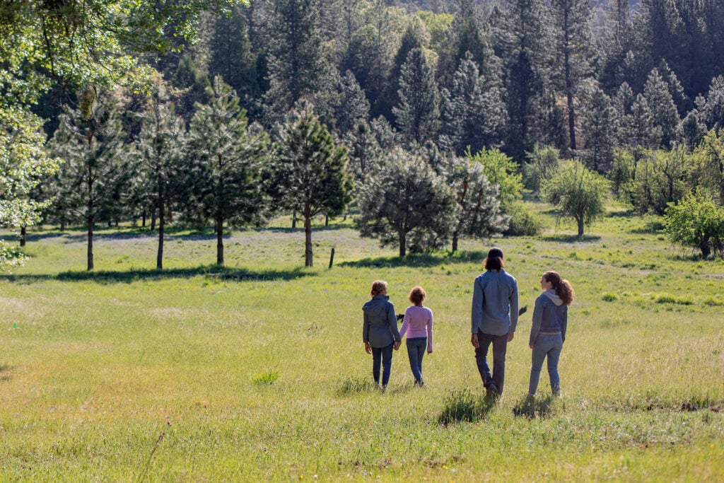 Multigenerational family walking into a meadow of a Memorial Forest
