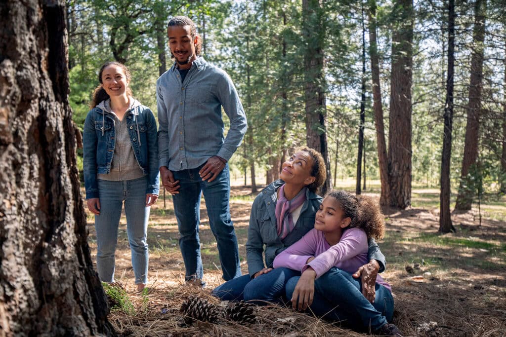Multi generational family gathers around a Memorial Tree in a Memorial Forest