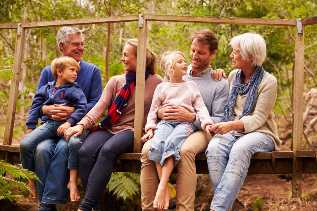 Happy multi-generation family walking in the meadow of a Memorial Forest