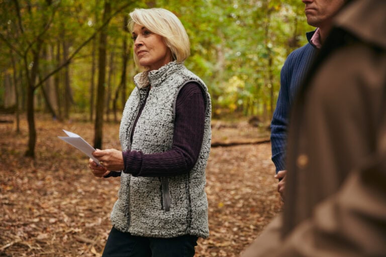Woman holding an Invitation to a Forest Memorial ceremony