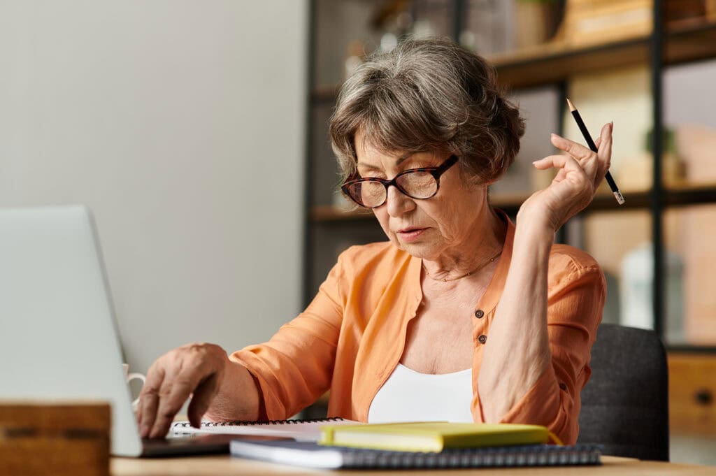 Senior woman enjoys a moment of reflection while writing in a cozy home environment