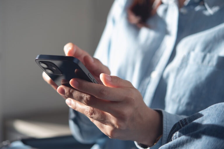 Woman texting on a mobile phone at home.