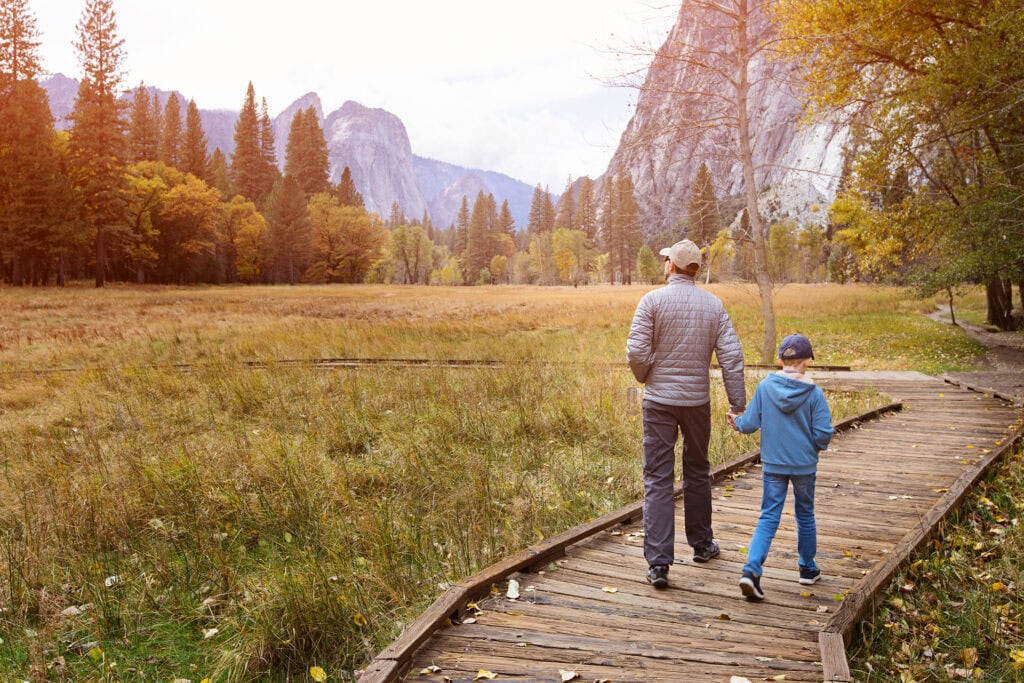 Father and son hiking on a trail in Yosemite National Park, California