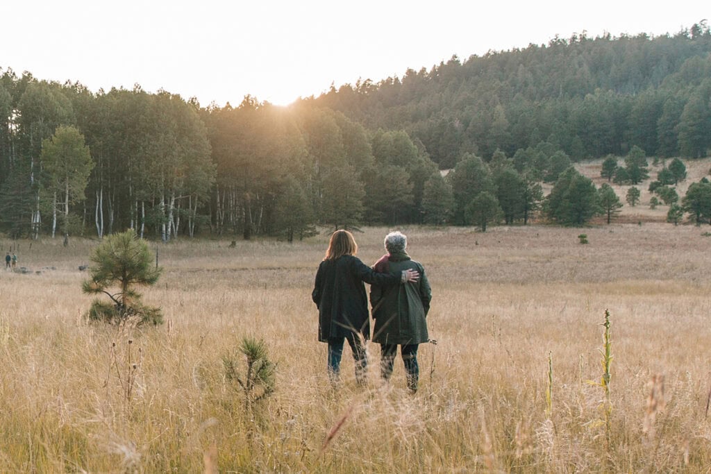 Mother and Daughter look at the horizon as the sun sets in a Memorial Forest