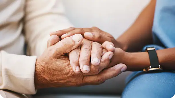 Nurse and patient holding hands in support, empathy, trust