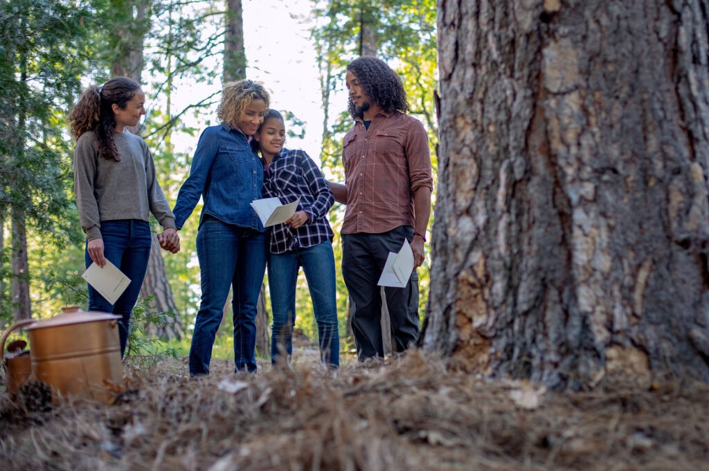 Family standing by a Memorial Tree at a Forest Memorial ceremony