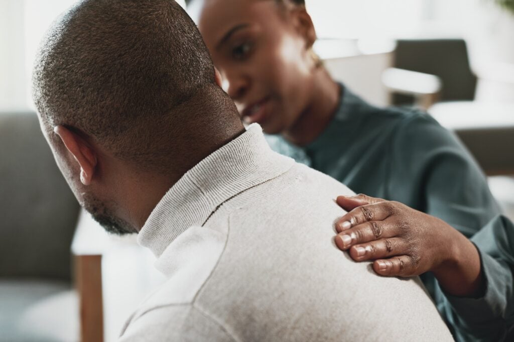 A man and woman comfort each other in grief support