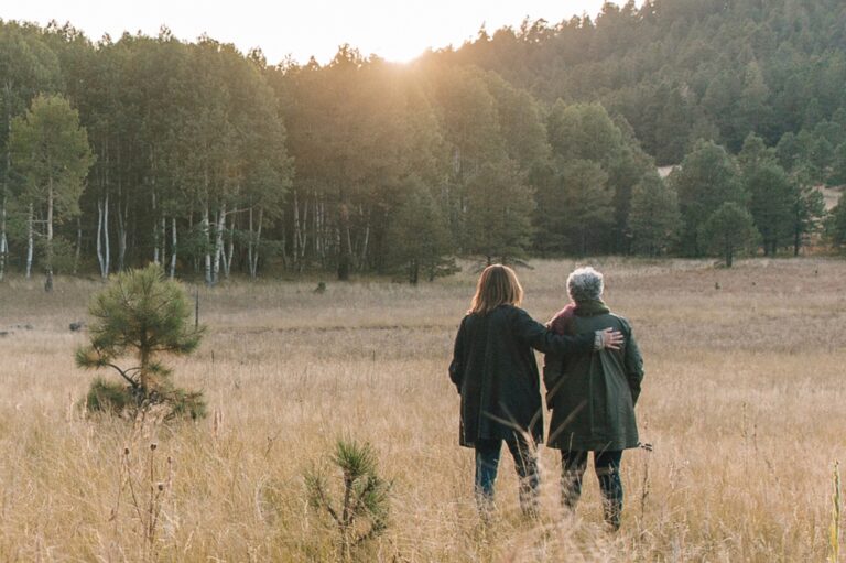 Two people standing together while the sunsets in a memorial forest