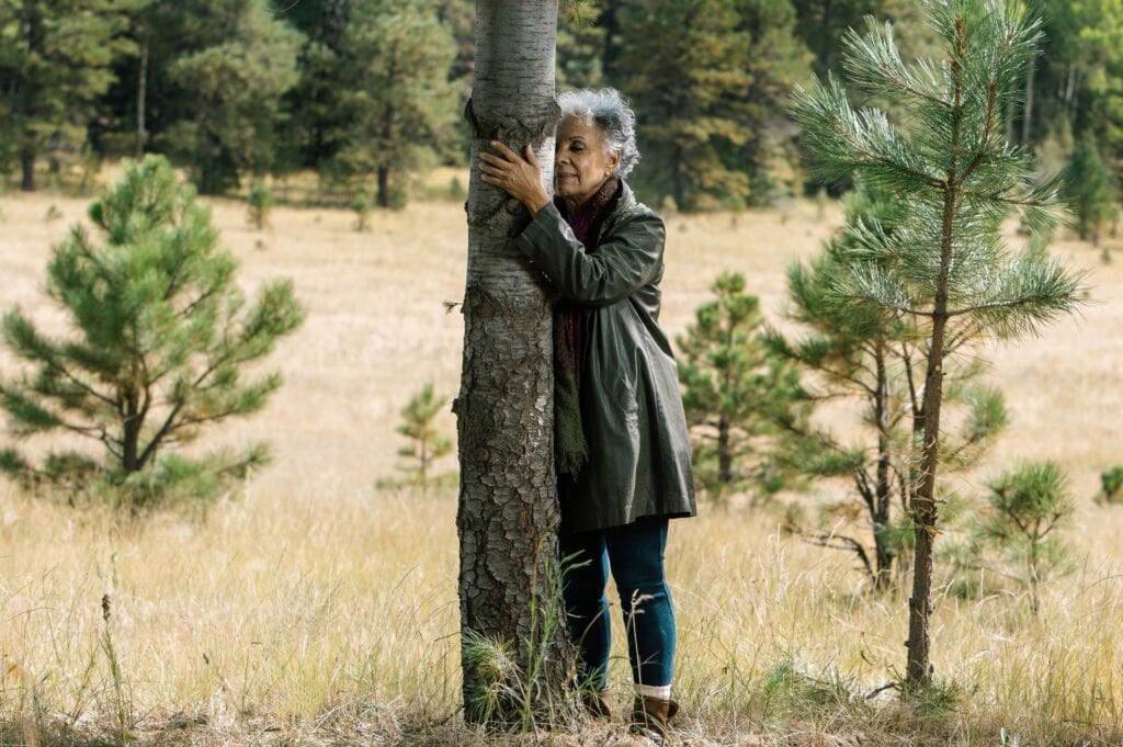 A woman leaning into a memorial tree