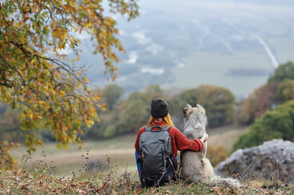 Woman with dog overlooking valley