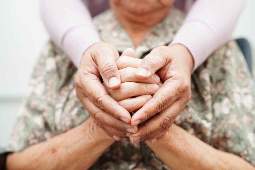 hands loving clasp an elderly hospice patient