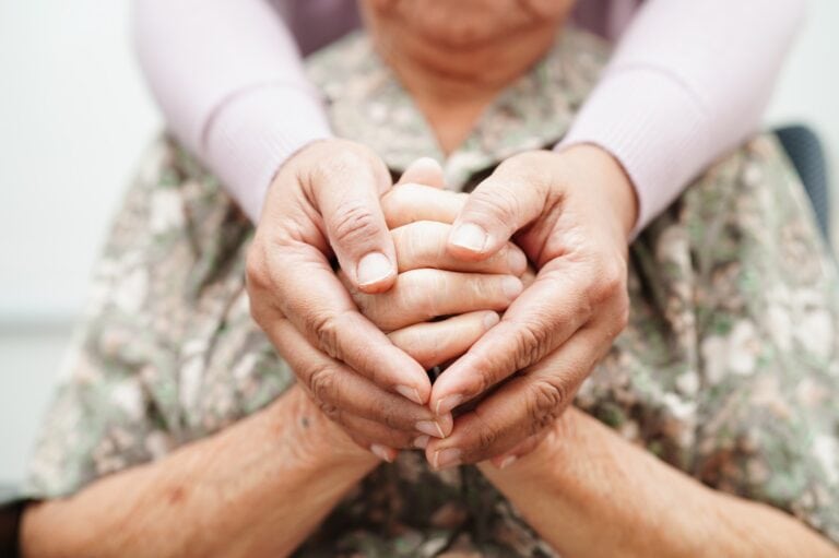 hands loving clasp an elderly hospice patient