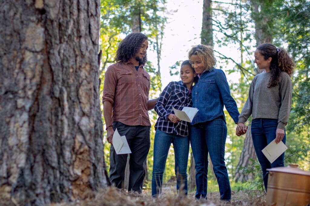 a group gathered around a memorial tree doing a celebration of life