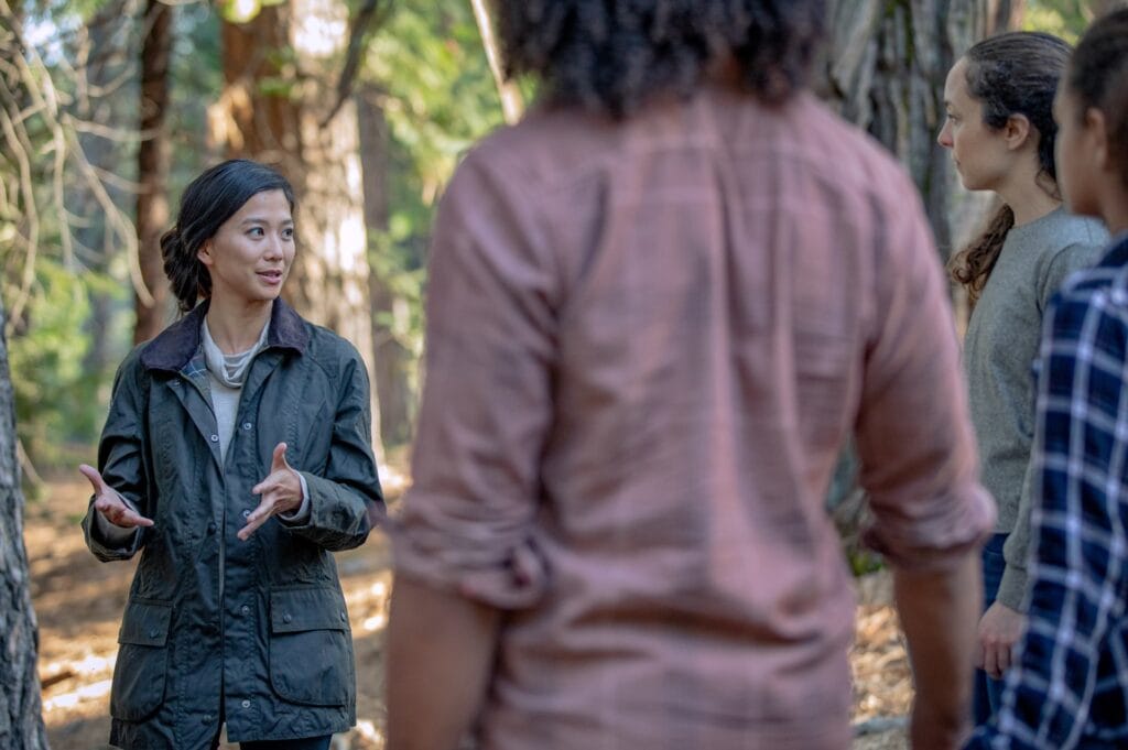 a forest guide explaining memorial trees to a group of people