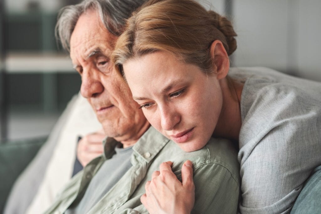 Daughter hugging her father sadly