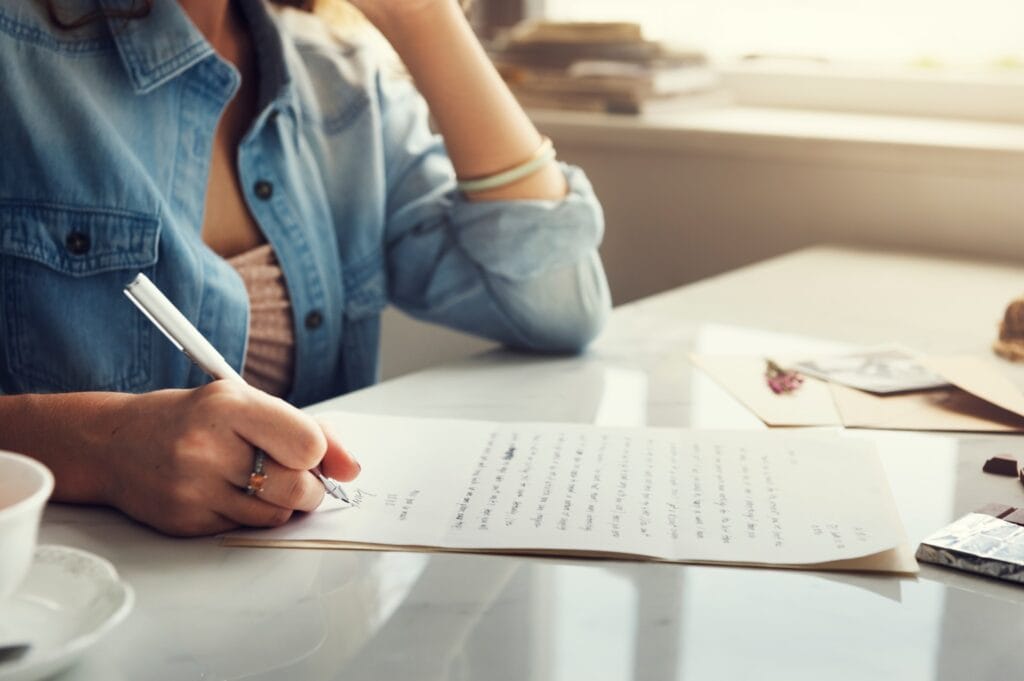 closeup of hands writing a memorial tribute
