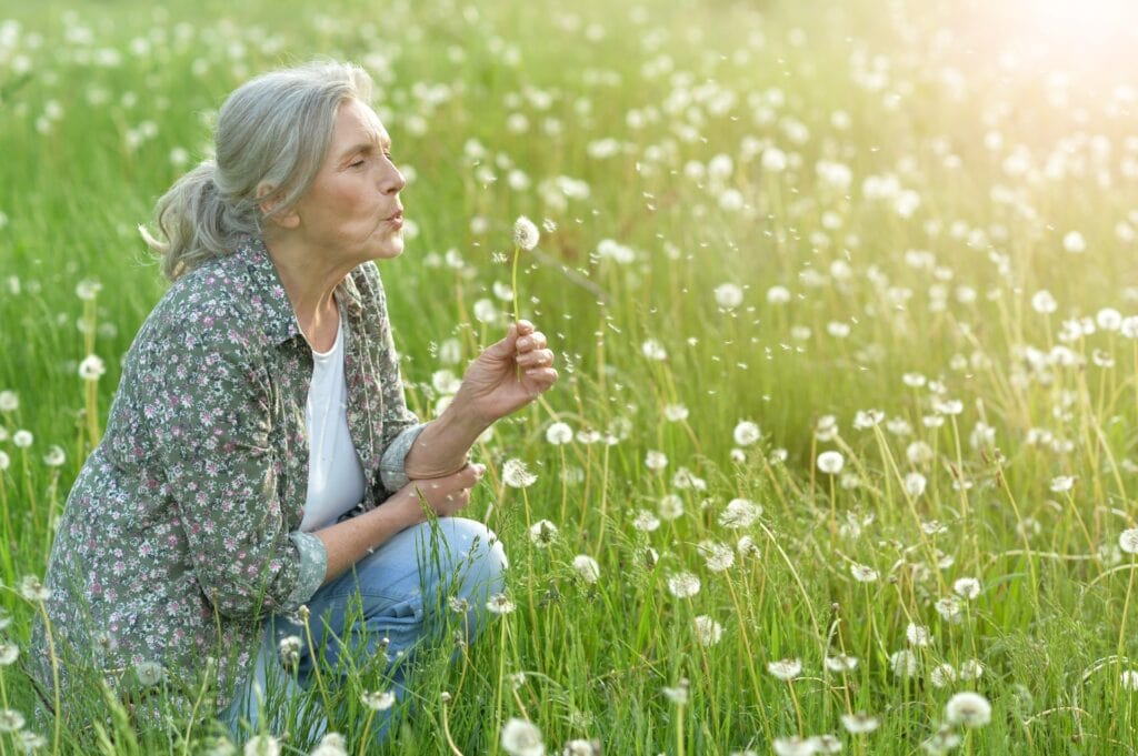 A woman sits in a field of flowers