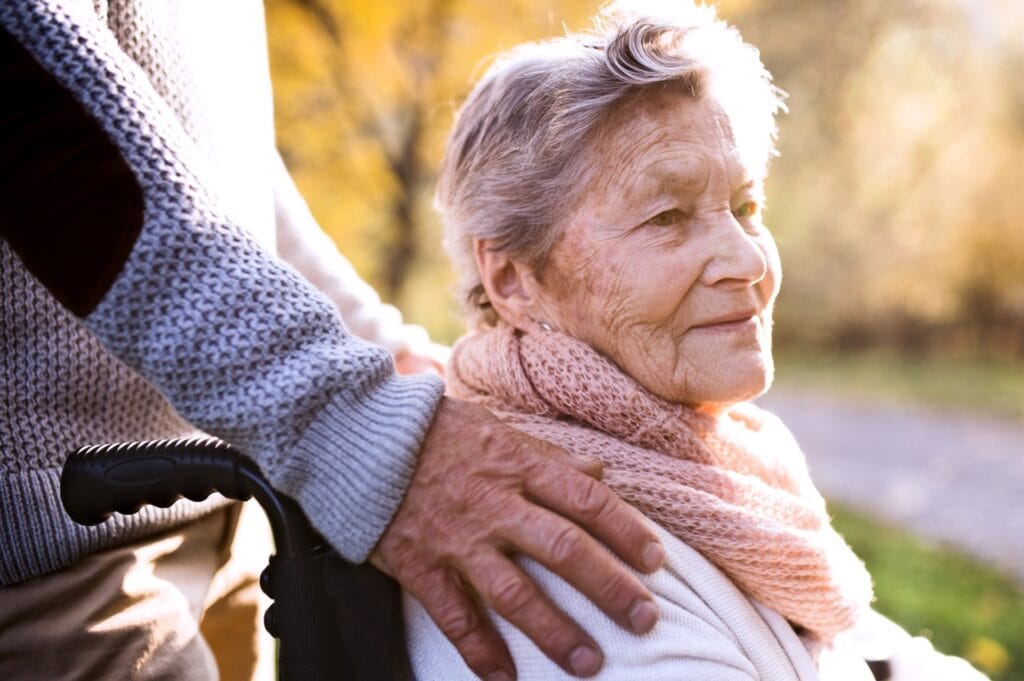 A son’s hand on his elderly mother’s shoulder