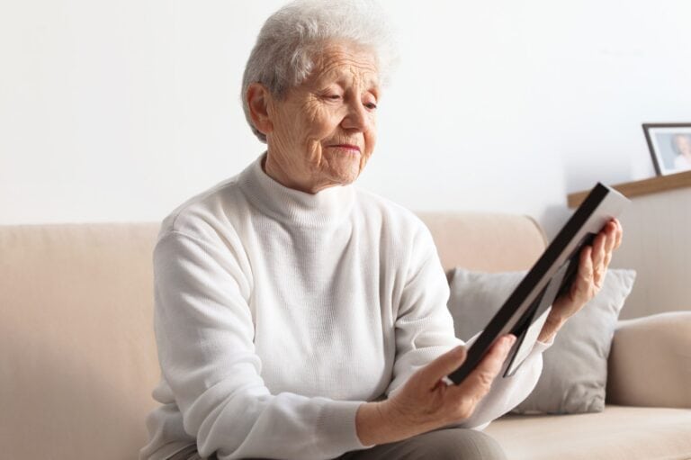 elderly woman looks at photo of a passed loved one