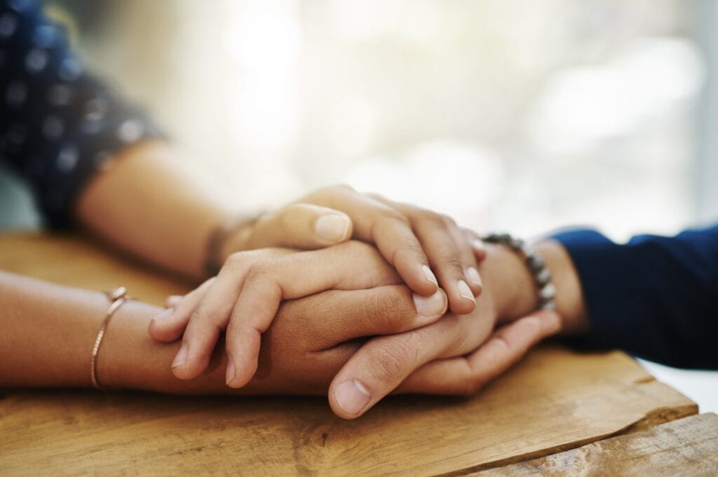 hands clasping in grief support