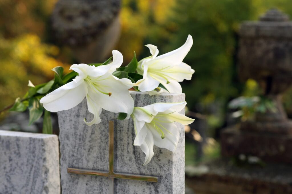 White lilies on granite tombstone