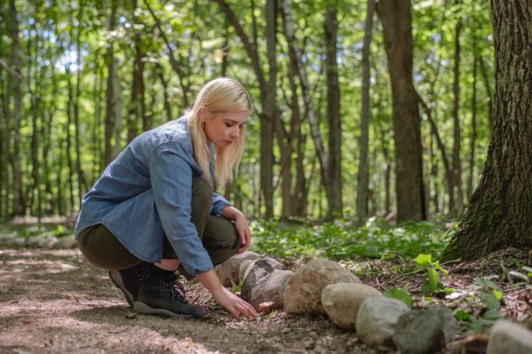 A woman spreads ashes in a memorial spreading grove