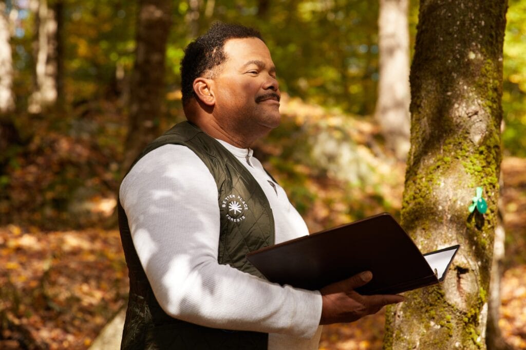 A family stands together at the base of a memorial tree