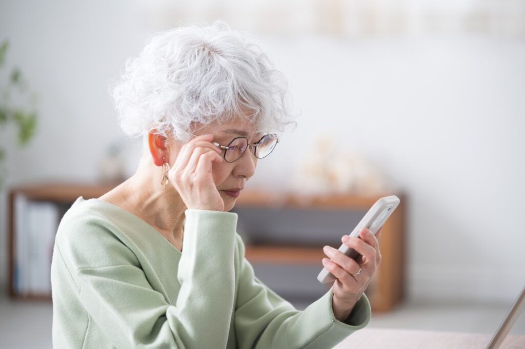 A woman using her phone to search online for an obituary 