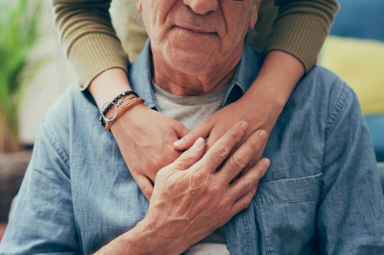 Woman places comforting hand on shoulder of her father