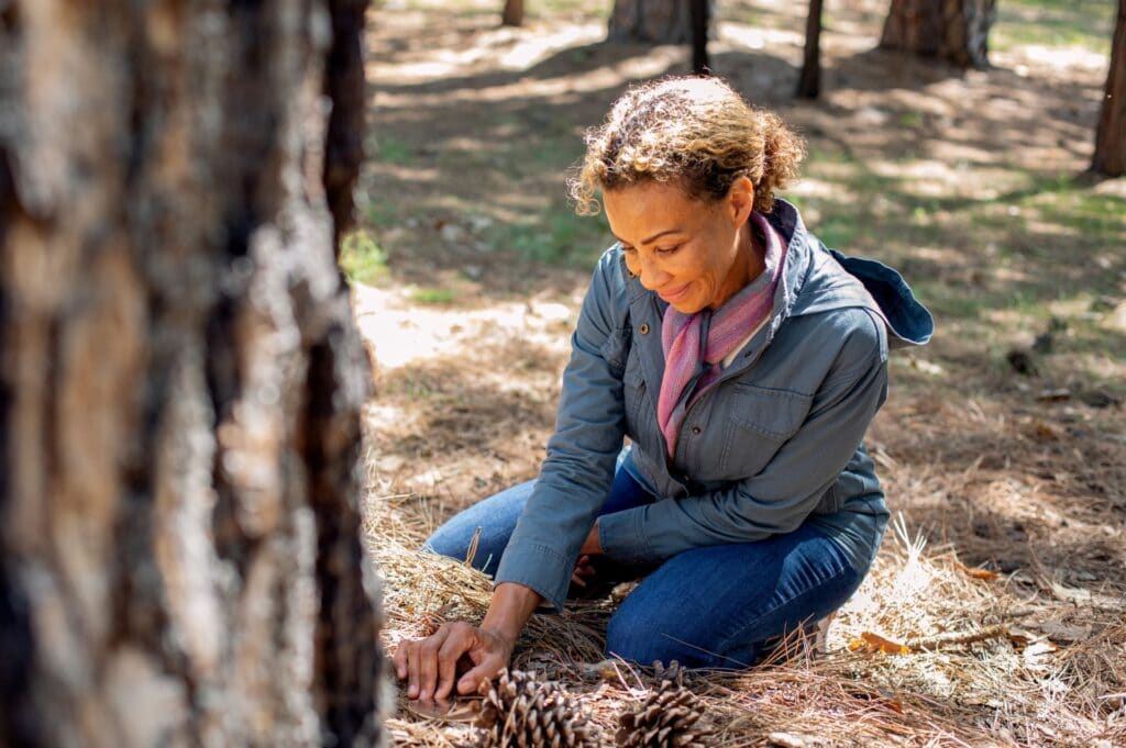 A woman touches the soil by a memorial tree