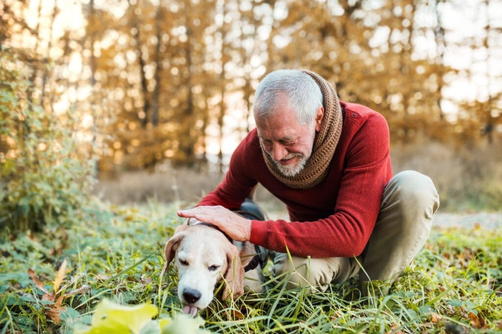 an elderly man petting his dog