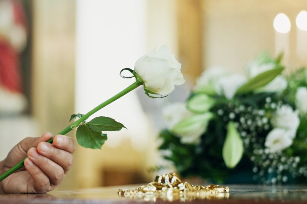 A white rose being placed at a funeral