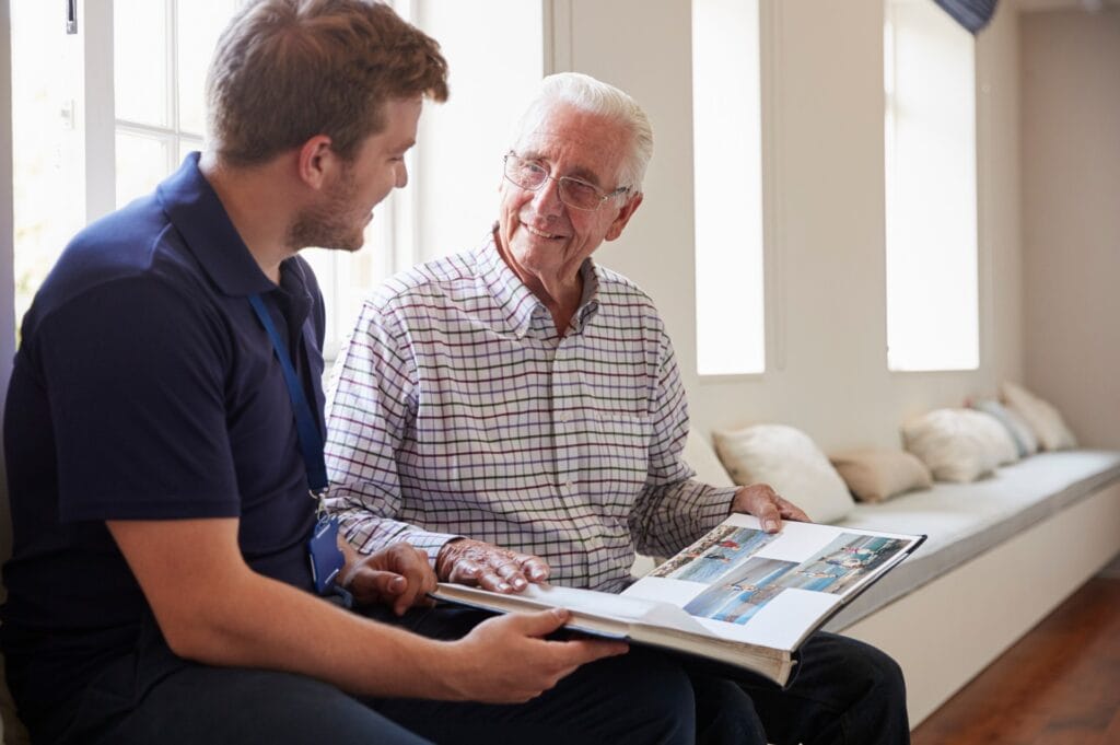 two men looking at a photobook containing memories of a deceased loved one
