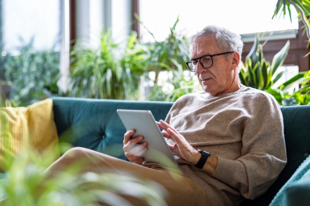 senior man sitting on couch planning a funeral