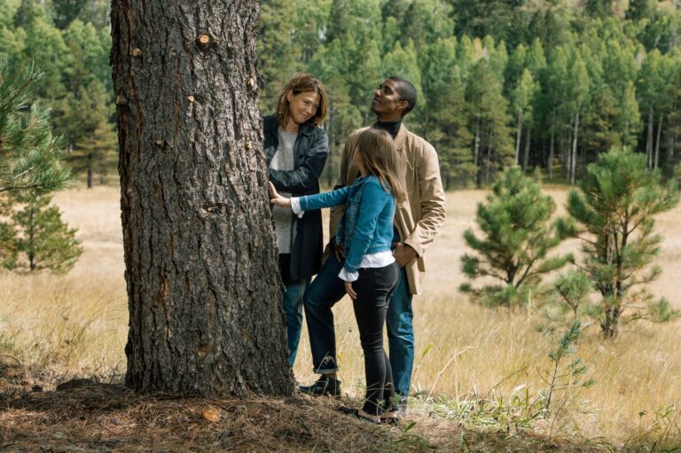 a family gathers around a tree in flagstaff memorial forest