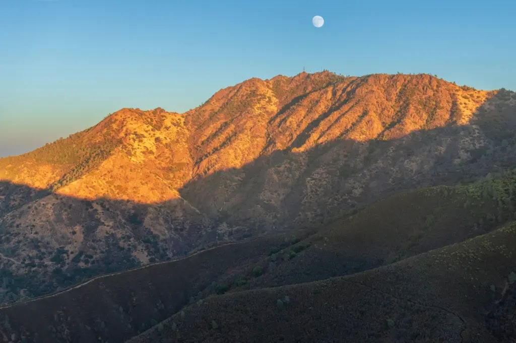 View of Mount Diablo's rolling hills with the moon above in the daytime.