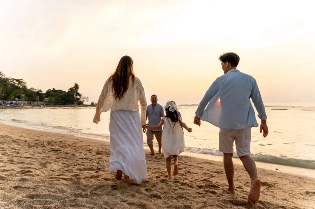 A multi-generational family enjoying a sunset on the beach.