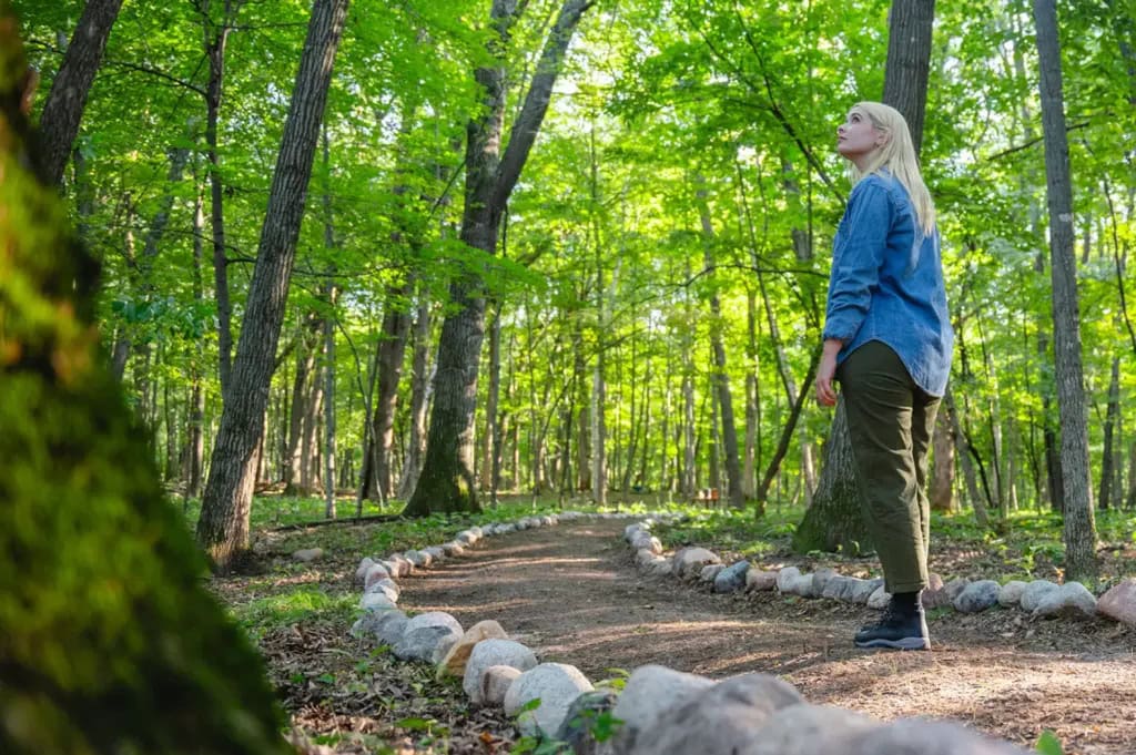 A woman scatters ashes of a loved one in a memorial forest