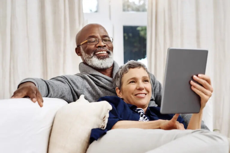 Older couple using a tablet to write an obituary