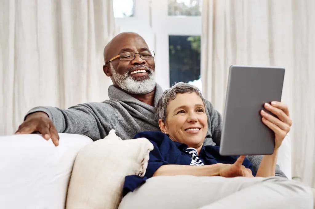 Older couple using a tablet to write an obituary