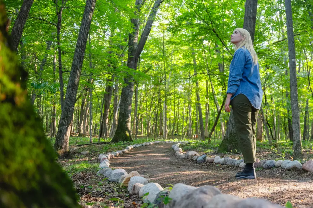 A woman scatters ashes of a loved one in a memorial forest