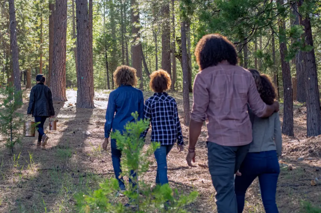 A family walks through a memorial forest on the way to a memorial service
