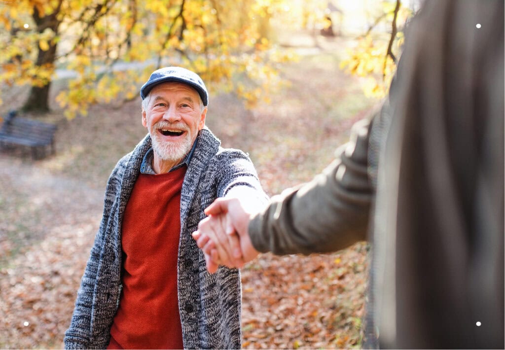 Senior father and adult son walking together in a forest, talking and reflecting on life and remembrance.