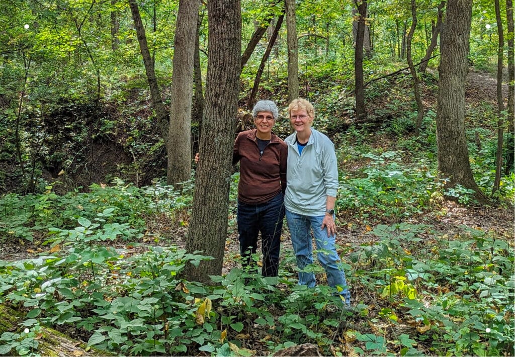 Dana and Laura stand together in front of their chosen Memorial Tree to share at Rock River Memorial Forest in Illinois.