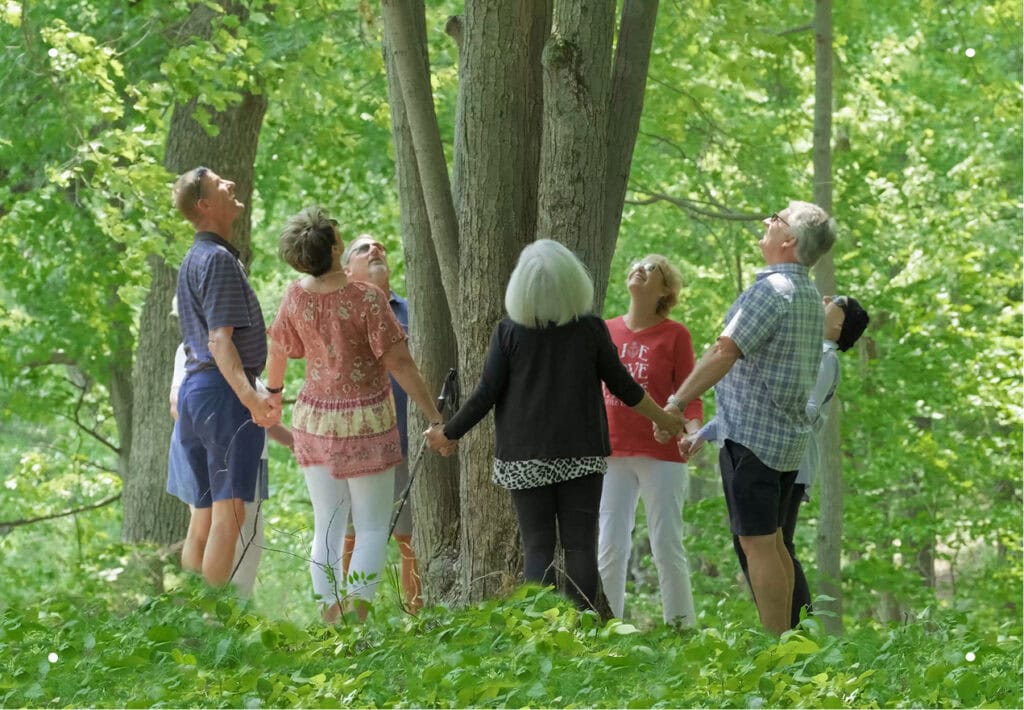 The Groves siblings stand in a circle holding hands around the Memorial Tree for their mother and father, that will one day be home to the entire family.