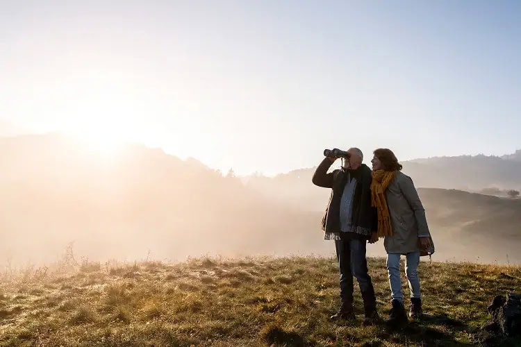 Senior couple walking through an autumn forest, symbolizing Everis’s commitment to balance, renewal, and carbon-neutral remembrance.