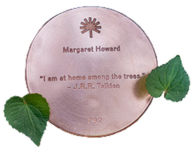 Close-up of a silhouetted circular bronze Memorial Marker.